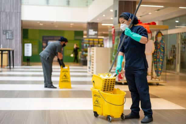 Dedicated shopping center cleaning staff maintaining the floor at a lively shopping mall, creating a clean and inviting environment.