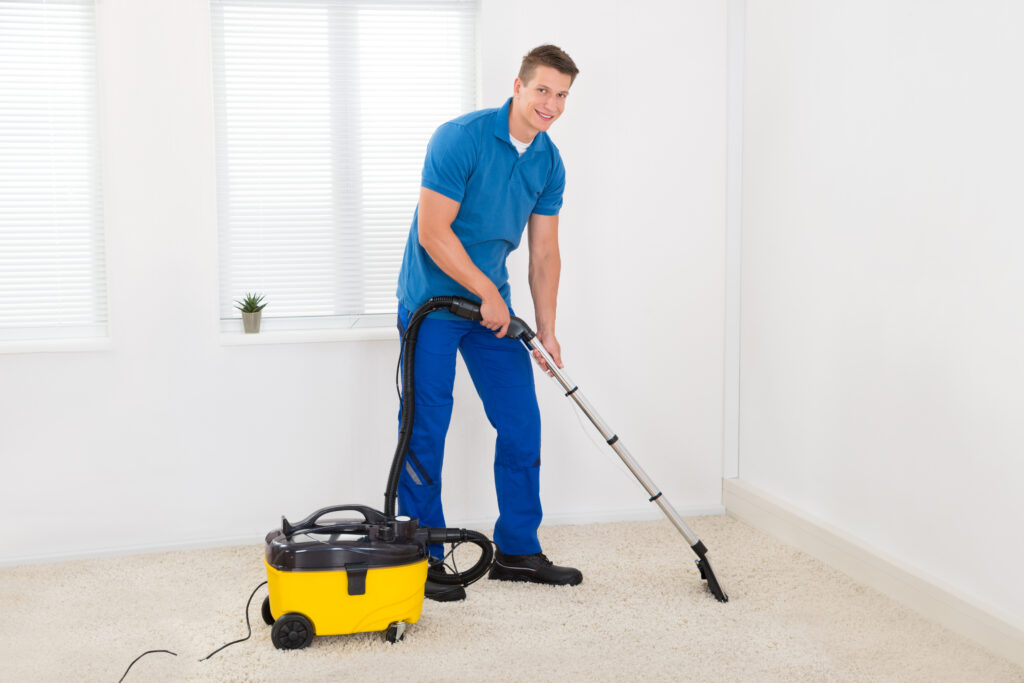 Happy,Male,Janitor,Cleaning,Carpet,With,Vacuum,Cleaner